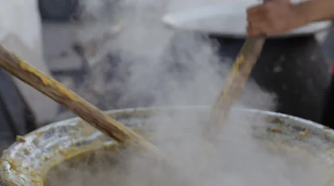 Panning closeup Indian men stir curry on street for community meal in India Stock Footage 33513754