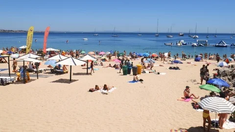 Panning of crowded sandy Conceicao beach in Cascais near Lisbon, Portugal during Stock Footage 112886927