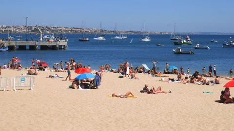 Panning of crowded sandy Praia do Ribeiro on a sunny day Stock Footage 114447782
