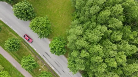 Panning diagonal overhead shot of a town road red and blue car passing by Video stock 132521014