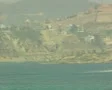 Panning distant view of castle, town and beach from sea SD Footage