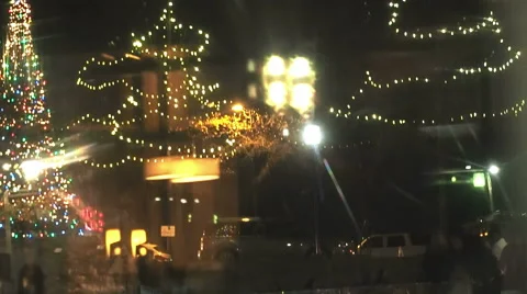Panning down to christmas lights at ice skating rink in downtown city Stock Footage 58553419