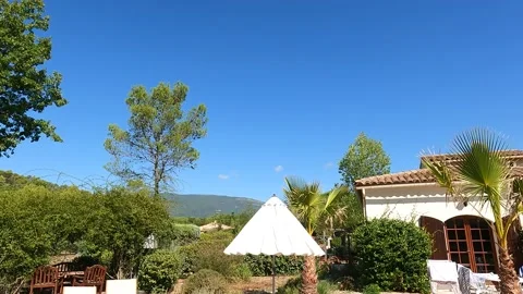 Panning down from clear blue sky to a girl sat by the pool Stock Footage 163608533
