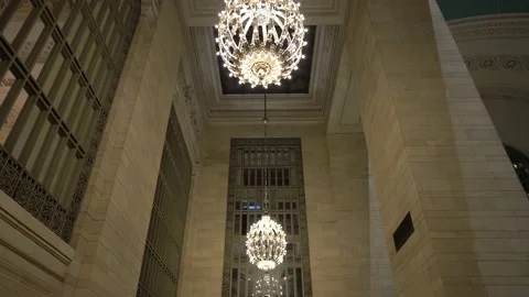 Panning down from Grand Central Station chandeliers to ramp with people Stock Footage 199728746