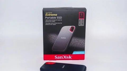 Panning down on a SanDisk SSD Drive and box on a white background.store. Stock Footage 157504383