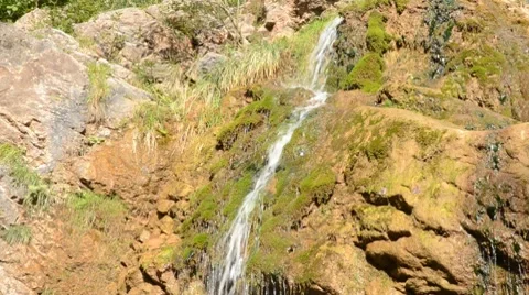 Panning down  a waterfall and along the creek Stock Footage 8623508