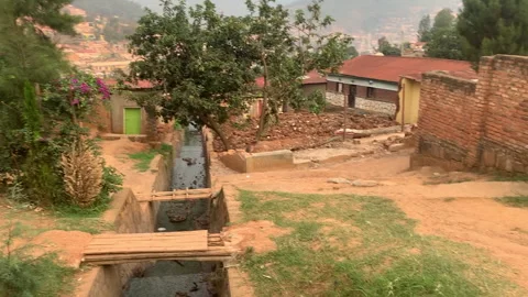 Panning from a drainage to a school in Rwanda Stock Footage 260668019