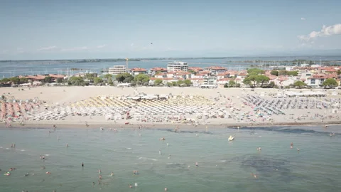 Panning drone aerial over crowded Grado beach Italy summer 4K Видео 331429461