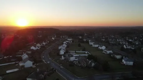 Panning Drone shot of a sunset over a quaint suburban town  Stock Footage 228699711