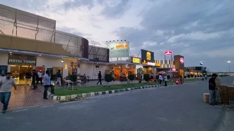 Panning dusk shot showing a highway midway rest area with outlets from moolchand Stock Footage 331314616