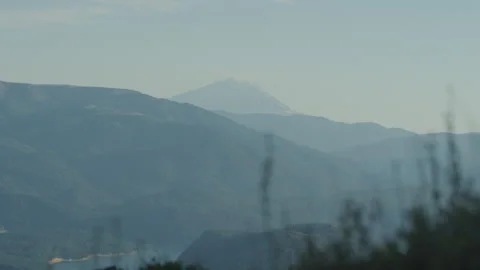 Panning on far view of Mount Saint Helens between blades of tall grass at sunset Vidéo 247900567