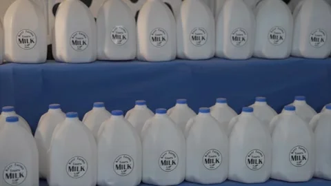 Panning gallons of milk on display Stock Footage 258852096