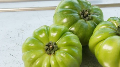 Panning on green tomatoes on silver tray. Video stock 109452124
