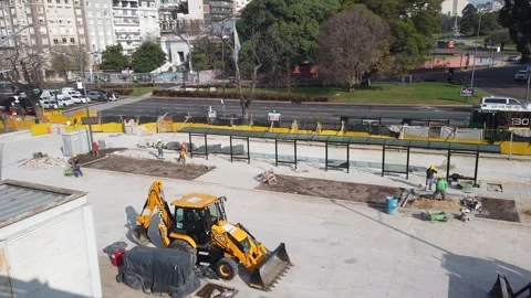 Panning High Angle View of Yellow Backhoe Excavator and Laborers at Street Stock Footage 337528322