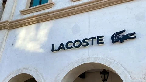 Panning left on the Lacoste retail store sign at a mall in Orlando, Florida. Stock Footage 160673121