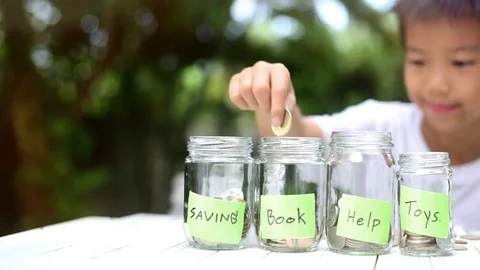 Panning from left to right Boy saving coin in can Stock Footage 80555479