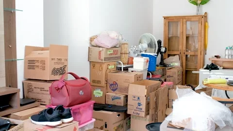 Panning left to right in messy room full of things packed in moving boxes Video stock 151939480