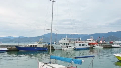 Panning left to right view boats and yachts with cargo ship leave port in Bat Vídeos de archivo 166160002