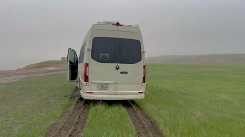 Panning left on a RV Sprinter Van stuck in the mud in the Wall, SD boondock.. Stock Footage 245176511
