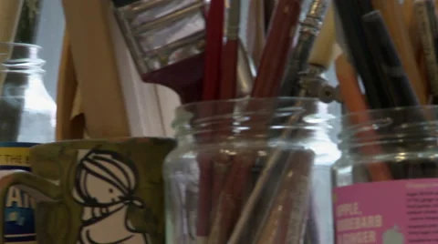 Panning Left Shot Across Jars of Pencils and Paintbrushes Stock Footage 57267476