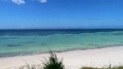 Panning left shot revealing an empty tropical sunny beach with turquoise Vidéo 231665407
