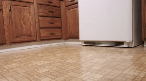 Panning Low Angle of Old Yellow Linoleum Kitchen Floor Stock Footage 61708820