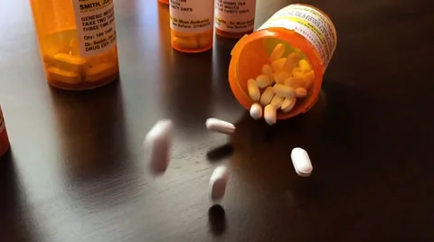 Panning of Medicine Bottles and Pills Falling Slo-Mo Stock Footage
