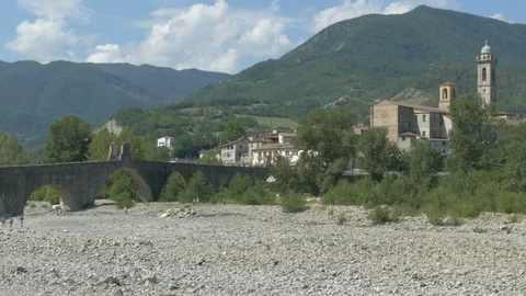 Panning on a medieval bridge in Italy, while people walk around and sunbathe. Stock-Footage 94122119