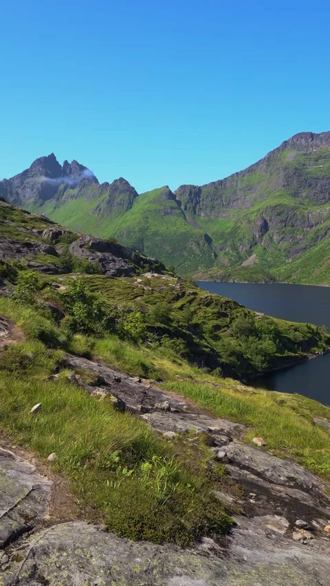 Panning motion reveals breathtaking views of rugged mountains, a tranquil l.. Stock Footage 297119499