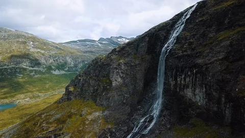 Panning out from stunning dramatic waterfall on a steep vertical cliff Stock Footage 99681108