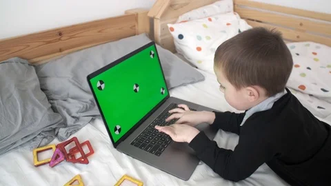 Panning Over Kid Playing Game on Laptop with Chroma key 動画素材 125462474