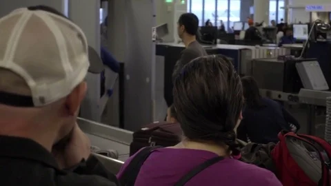 Panning people as they wait on crowded long line for security check in airport Stock Footage 70110247