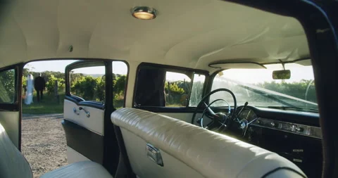 Panning right - Interior of vintage car with wedding couple. Stock Footage 206486331
