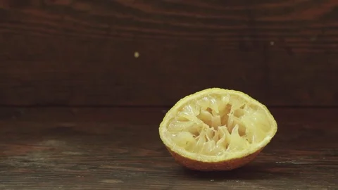 Panning to right on used lemon half on vintage wood background Stock Footage 80350785