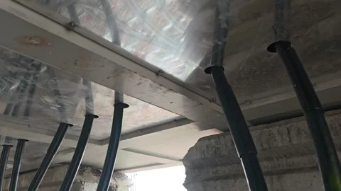 Panning right video of heavy black underground electrical power cables entering  Stock Footage 338355557