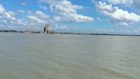 Panning of a river, waves, cloudy sky, and industrial areas from the river. Video stock 221114701