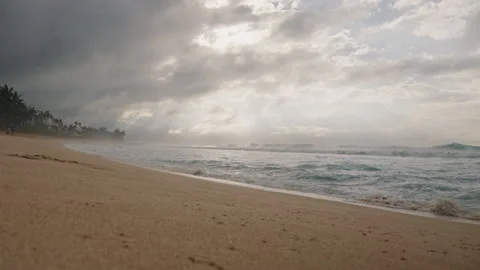 Panning Up from Sandy Beach to Waves Crashing on Beach and Dramatic Sky 4K Stock Footage 267048661