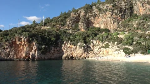 Panning from scenic coastal cliffs to white pebble beach 스톡 동영상 332861010