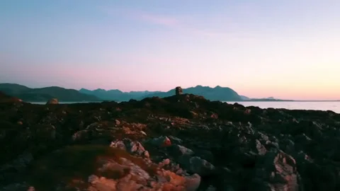 Panning Scenic Shot Of Rocks Stack On Landscape By Rippled Sea During Sunset - Stock Footage 233997965