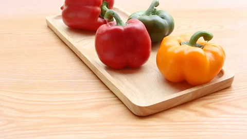 Panning short Multi Colored Bell Pepper Placed on wood plate Video stock 154923947