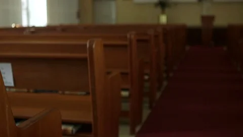 Panning shot across rows of classic wooden pews in a large church Stock Footage