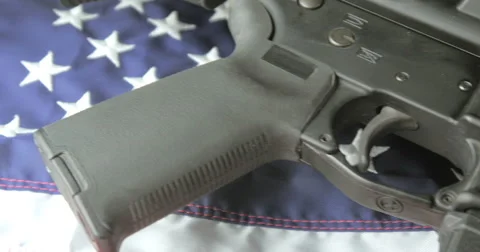 Panning Shot of an Assault Rifle Lying on an American Flag Stock Footage 61297028