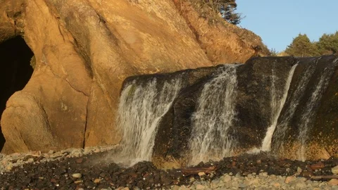 Panning shot of beach waterfall, Oregon Coast Video stock 102403167