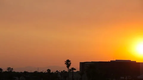 Panning Shot of Beautiful Sunset Over a Building and Palm Trees Stock Footage 61839807