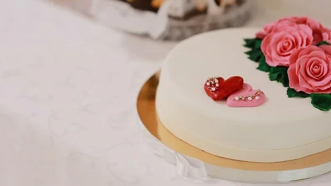 A panning shot of a beautiful wedding cake with heart decorations. Stock Footage 129463100