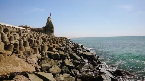 Panning shot of breakwater, lighthouse, temples near dwarka beach Gujarat india Stock Footage 101805875