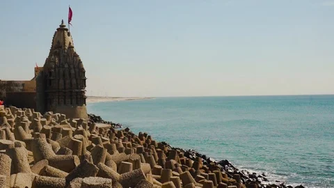 Panning shot of breakwater, lighthouse, temples near dwarka beach Gujarat india Stock Footage 101806625