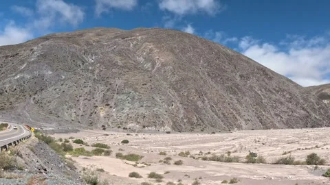 Panning Shot of Bridge over Dry Riverbed Amidst Mountains Stock Footage 296322810