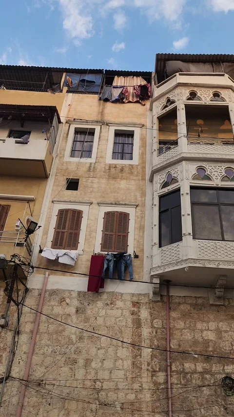 A panning shot of a building with multiple balconies and clothes hanging Stock-Footage 314247255