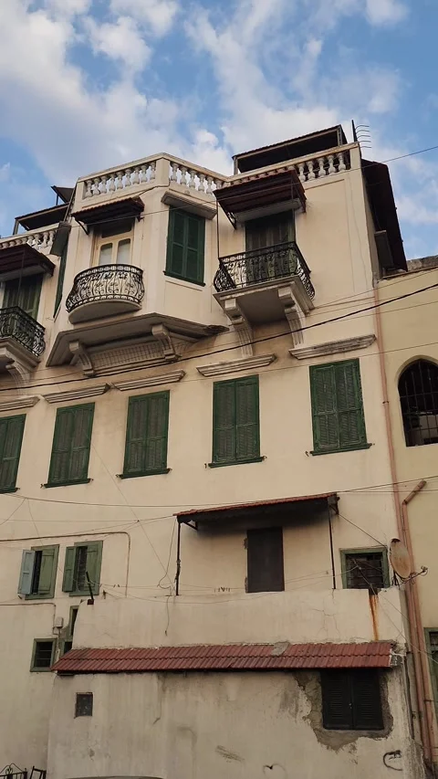 A panning shot of a building with multiple green-shuttered windows Stock-Footage 314172663